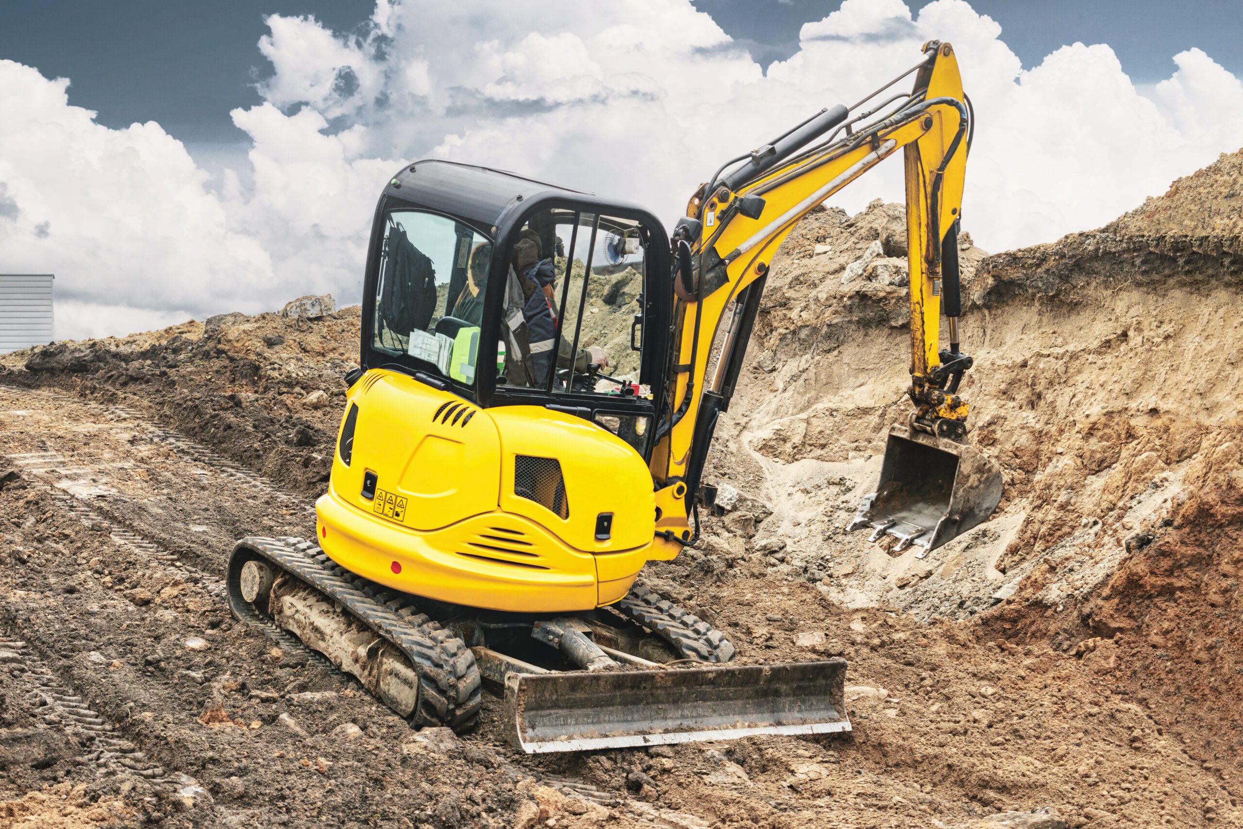 Mini excavator at the construction site. Compact construction equipment for earthworks. An indispensable assistant for earthworks. Rental of construction equipment.